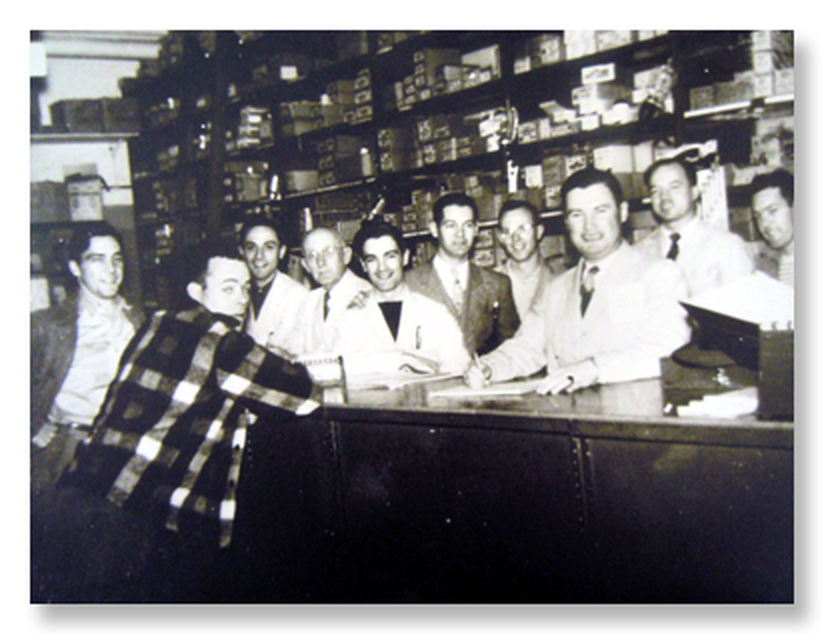 Frank P. McCartin and team behind the store counter, historic photo